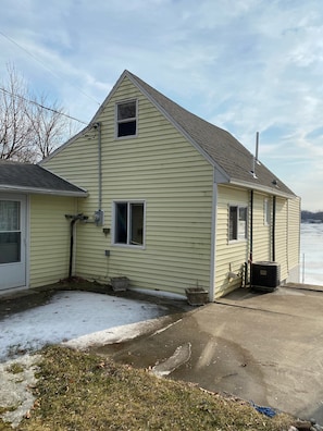 A two-story house with a gabled roof, a chimney, and a small porch. - Cute cottage on all sports lake (Vestaburg)