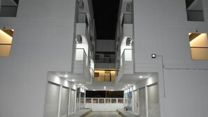 A modern building with a central atrium, multiple balconies, and a gated entrance. - Hotel Kai Soledad (Soledad)