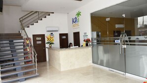 A hotel reception area with a marble counter, a staircase, and a glass wall. - Hotel Kai Soledad (Soledad)
