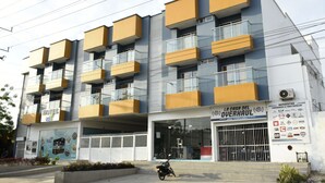 A multi-story hotel with balconies, a visible entrance, and a sign for 'La Casa del Overhaul'. - Hotel Kai Soledad (Soledad)