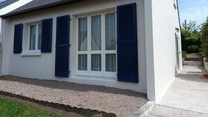 A two-story house with a white exterior and dark blue shutters on the windows.