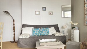 Ein Schlafzimmer mit Bett, Nachttisch, Stuhl und einem kleinen Tisch mit Tablett.