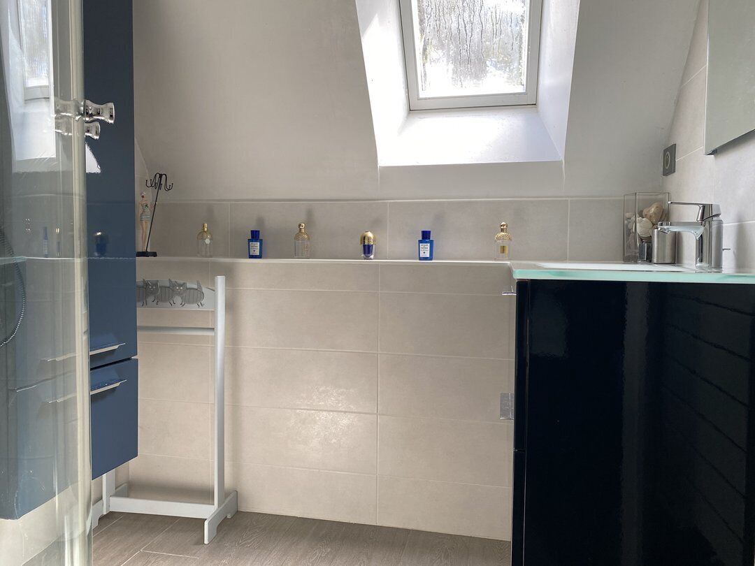 Eine moderne Küche mit Dachfenster, weißen Schränken und einer Arbeitsplatte mit verschiedenen Gegenständen.