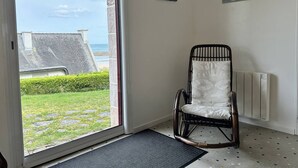 A room with a view of the sea, a rocking chair, and two paintings on the wall. - Sea-view house in Erquy | 8 guests | Ref 70 (ERQUY)