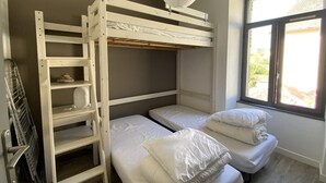 A bunk bed room with a ladder, a window with a view, and a hanging light fixture. - Apartment near beach in Erquy | 5 guests | Ref 653 (ERQUY)