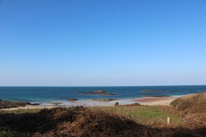 A coastal landscape with a clear sky, rocky outcrops, and a sandy beach. - House 50 m from the beach in Erquy | Ref 702 (ERQUY)