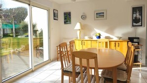 A dining area with a round table, wooden chairs, and a yellow cabinet. - House with garden in Erquy | 6 guests | Ref 602 (ERQUY)