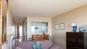 A living room with a sofa, a wooden cabinet, and a mirror. - Sea-view apartment in Erquy 50 m from the beach | 4 guests | Ref 411 (ERQUY)