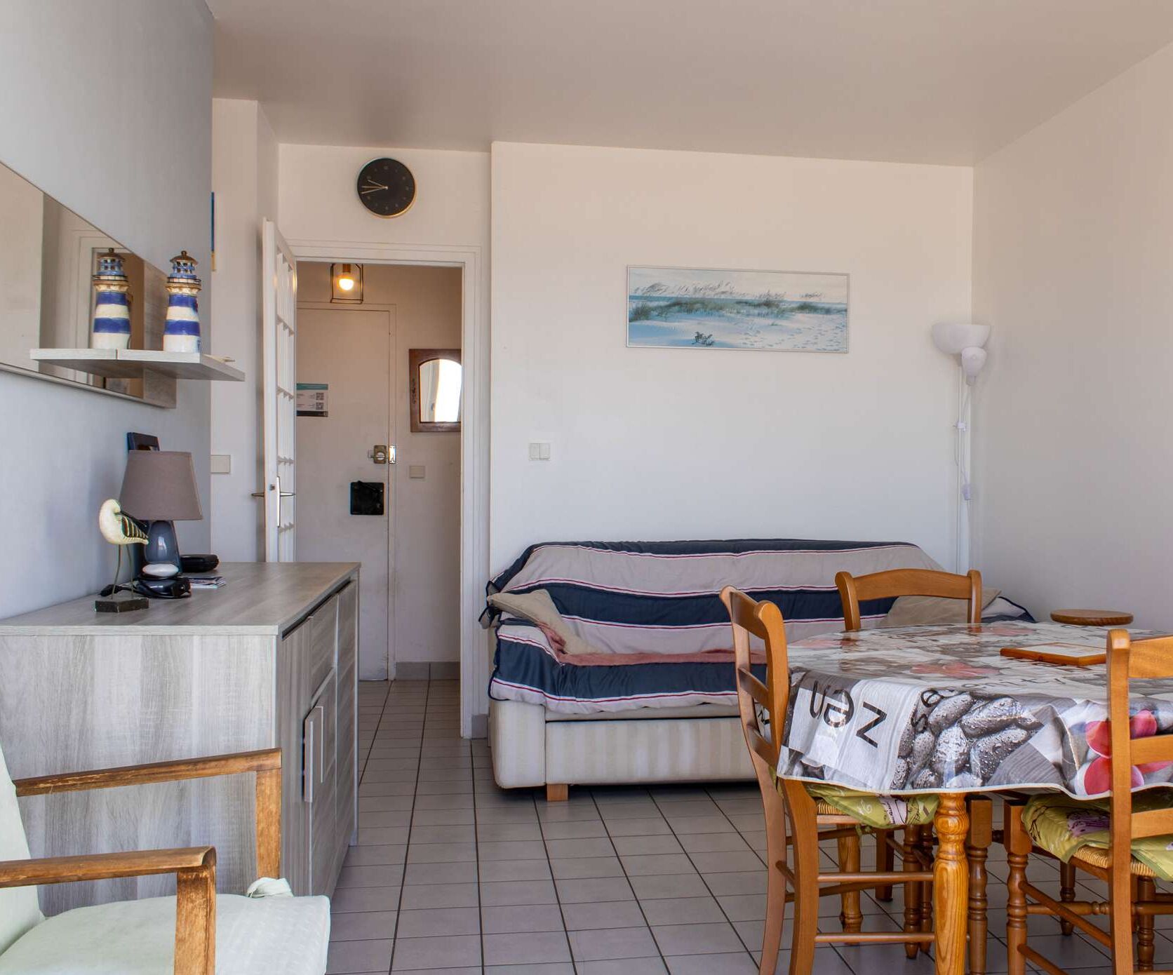 A compact room with a bed, a desk, and a dining table.