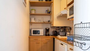 A compact kitchen with a microwave, coffee maker, and dishwasher. - Sea-view apartment in Erquy | 4 guests | Ref 514 (Erquy)