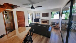 Ein modernes Wohnzimmer mit einem Holzesstisch, einer Couch und einem Kamin.