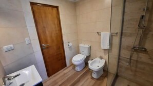 Ein Badezimmer mit Toilette, Bidet und einer Duschkabine.