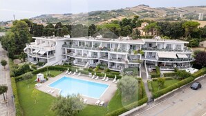 Un hôtel moderne doté d’une piscine, de nombreux balcons et offrant une vue sur les collines environnantes.