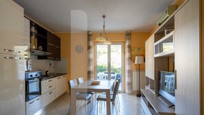 Une cuisine moderne avec une table à manger, des chaises et un téléviseur.