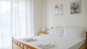 A hotel room with a bed, a bedside table with a lamp, and two framed pictures on the wall. - G.Bay D02 - Ground floor apartment with balcony, hill view (Foggetta)