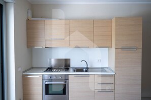 Eine moderne Küche mit Holzschränken, Edelstahlgeräten und einer weißen Arbeitsplatte.