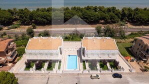 A two-story building with a central swimming pool, surrounded by a parking area and a view of the sea. - The recently-built Résidence Cerrano Park comprises two buildings with 12 three-room apartments, and offers guests the unique opportunity to enjoy breakfast or lunch with a breathtaking view of the surrounding countryside. (Foggetta)