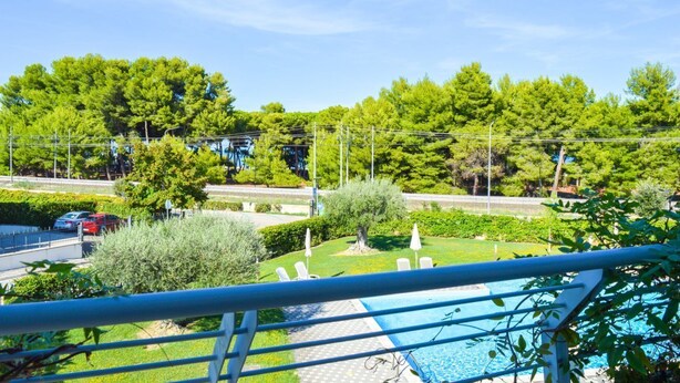 Un espace piscine avec vue sur une route et des arbres.