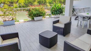 A covered outdoor patio with wicker furniture, a table, and potted plants. - Mykonos B7 - Apollo - 2-room apartment with terrace and sea view (Pineto)