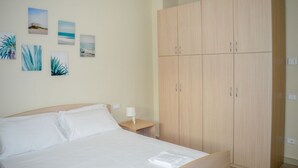A bedroom with a bed, a nightstand, a wardrobe, and wall art. - The recently-built Résidence Cerrano Park consists of two buildings with 12 three-room apartments, and offers guests the unique opportunity to have breakfast while enjoying a breathtaking view of the m (Foggetta)