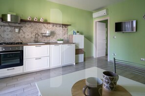 Una cocina moderna con armarios blancos, horno empotrado y microondas.