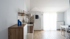 Eine moderne Küche mit einer Holzarbeitsplatte, einem eingebauten Herd und einem Essbereich mit Tisch und Stühlen.