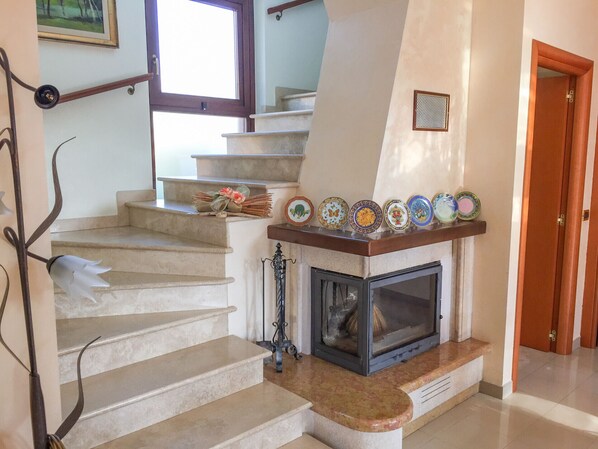 A staircase with a fireplace, a window, and a door. - Independent villa on three levels (Pineto)