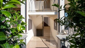 A multi-level residential building with a staircase leading to an upper balcony.