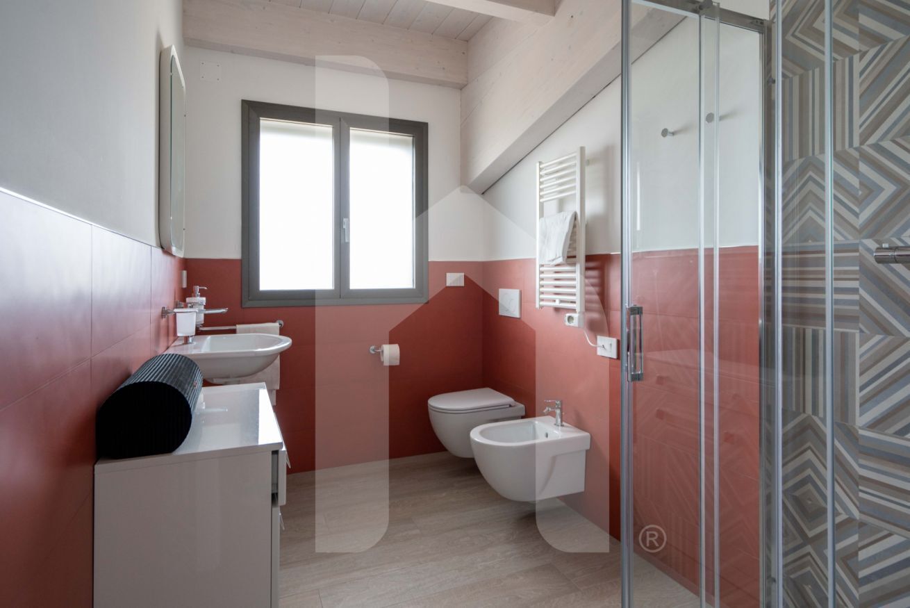 A modern bathroom with a toilet, bidet, and sink.