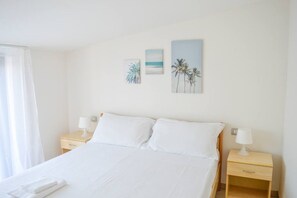 A hotel room with a bed, two bedside tables, and wall art. - G.Bay C28 - Second floor apartment with balcony and hill view (Foggetta)