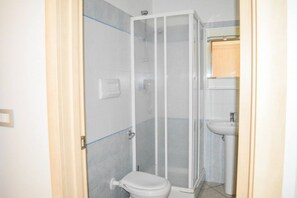 A small, enclosed shower area with a glass door, a white toilet, and a sink. - G.Bay C28 - Second floor apartment with balcony and hill view (Foggetta)