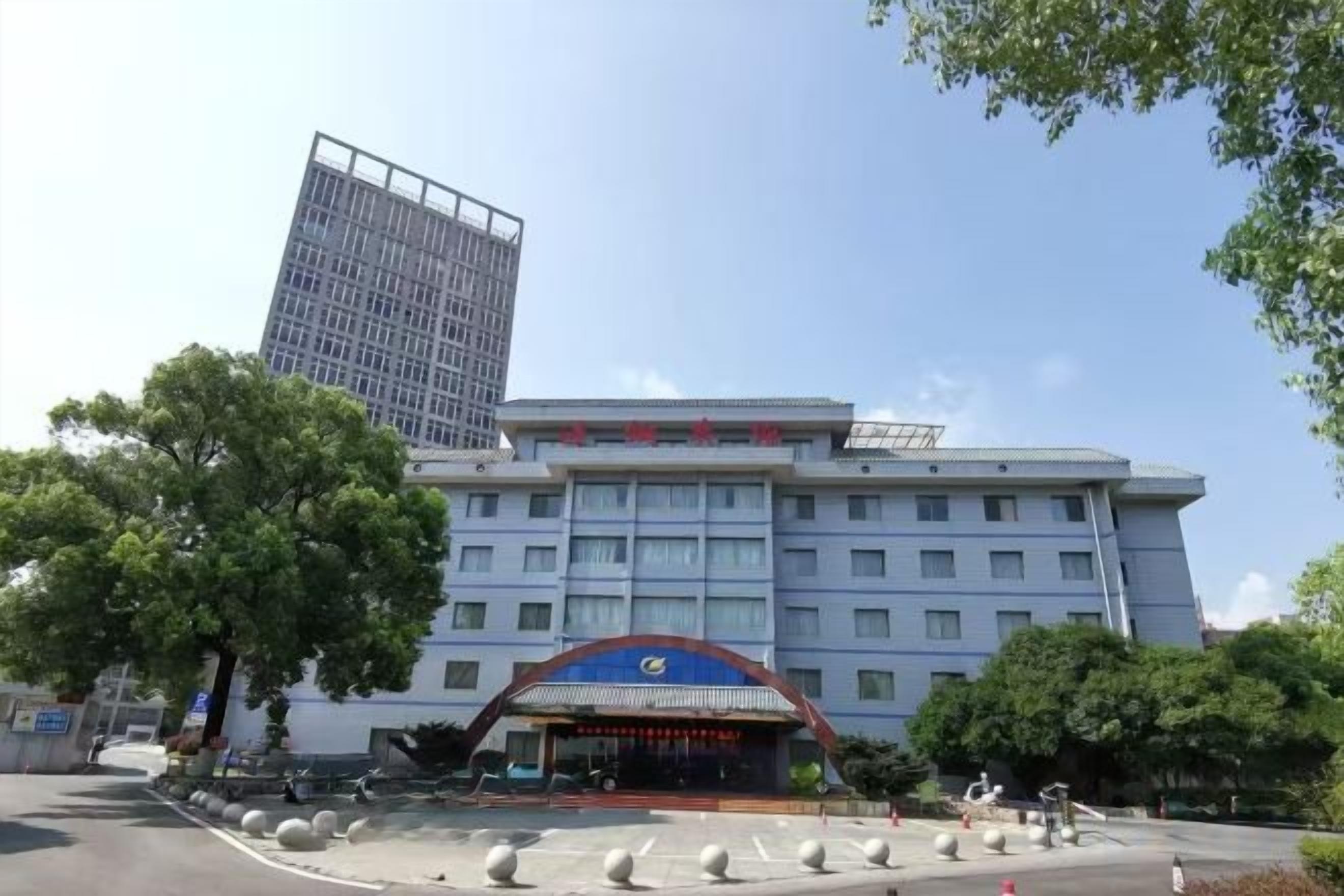 A hotel with a large building and a smaller structure with a blue roof.
