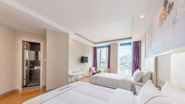 A hotel room with two beds, a desk, a chair, and a TV. - Ruiya Holiday Hotel (Dianjiang County)