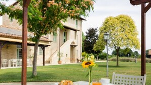 Une table dressée à l’extérieur avec des aliments pour le petit-déjeuner, un tournesol et un bâtiment en arrière-plan.