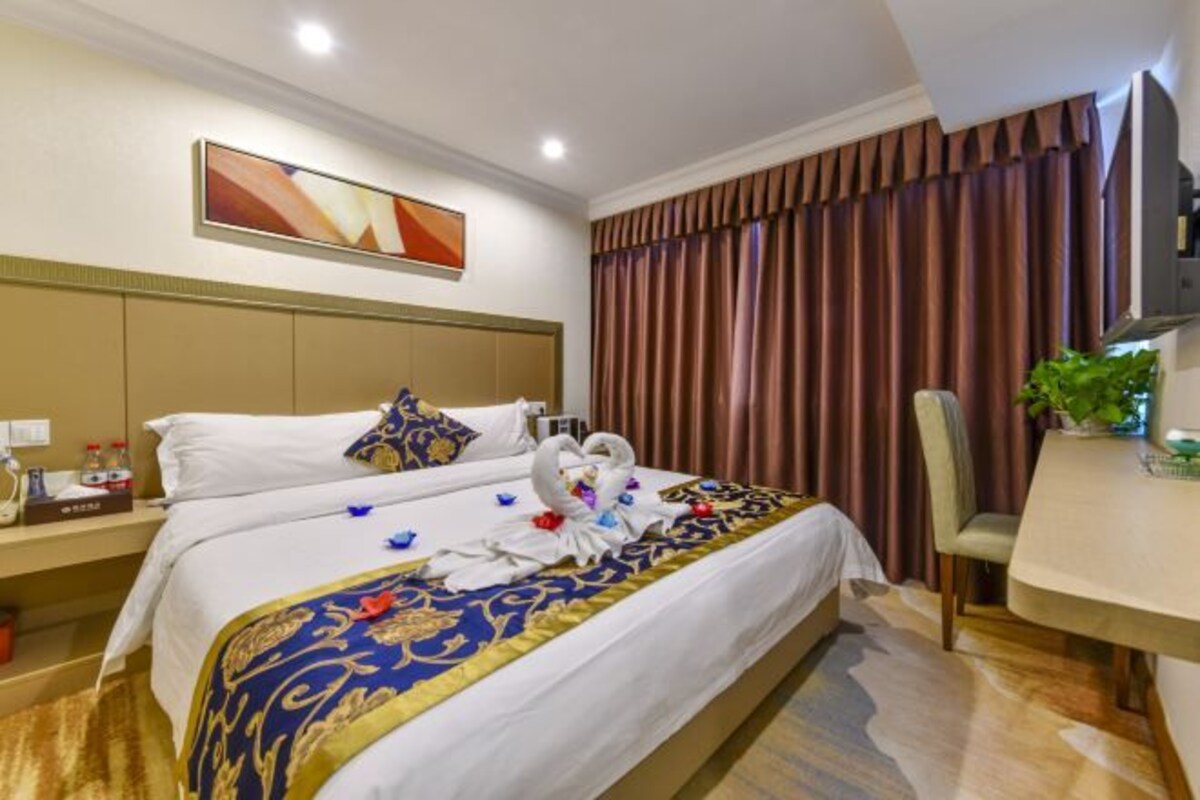 Une chambre d’hôtel avec un grand lit, un bureau et une chaise.