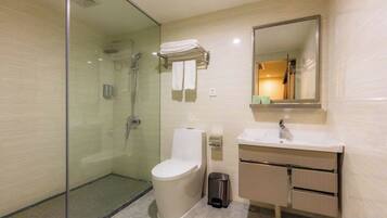 A modern bathroom with a glass-enclosed shower, a toilet, a sink, and a mirror.