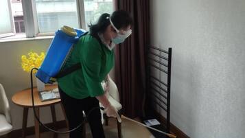 A person cleaning a room with a vacuum cleaner.