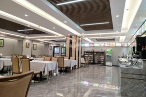 A spacious dining area with tables and chairs, a counter with a display, and a modern ceiling design. - Jinbiwan Hostel (Kaiping)