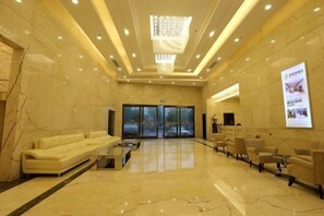 A spacious lobby with a marble floor, a sofa, chairs, and a chandelier. - Jinbiwan Hostel (Kaiping)