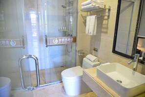 A hotel bathroom with a glass-enclosed shower, a toilet, a sink, and a mirror. - Jinbiwan Hostel (Kaiping)