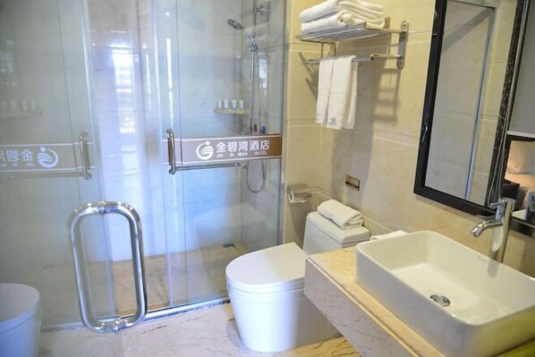 A hotel bathroom with a glass-enclosed shower, a toilet, a sink, and a mirror. - Jinbiwan Hostel (Kaiping)
