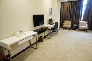 A hotel room with a desk, computer, TV, two armchairs, and a small table. - Jinbiwan Hostel (Kaiping)