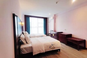 A hotel room with two beds, a desk, a chair, a bench, and a window with curtains. - Deyuan Hotel (Shaoguan Nanhua Temple) (Shaoguan)