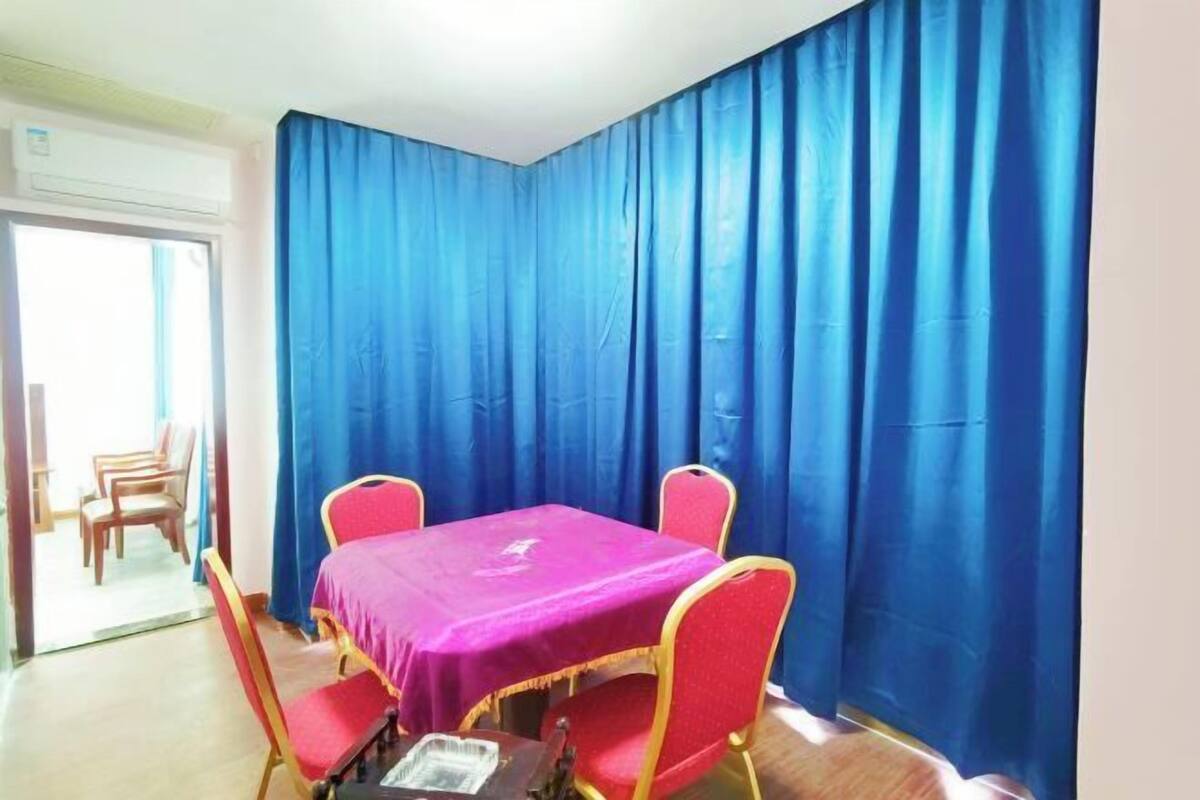 Een kamer met een tafel, stoelen, een raam en een deur.