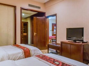 A hotel room with two beds, a wooden cabinet, a television, and a mirror. - Deyuan Hotel (Shaoguan Nanhua Temple) (Shaoguan)