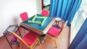 A small room with a table, chairs, and a window with curtains.