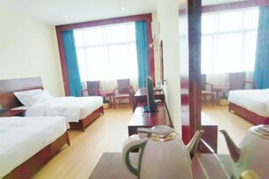 A hotel room with two beds, a desk, a chair, a kettle, and a large window with curtains. - Deyuan Hotel (Shaoguan Nanhua Temple) (Shaoguan)