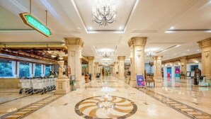 A spacious lobby with a central circular design on the floor, chandeliers, and a reception area with a statue. - the First World Hotel (Songcheng Hangzhou Paradise Tourist Area) (Hangzhou)