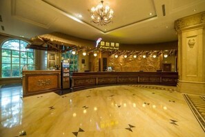 A reception desk with a chandelier, a reception area, and a marble floor with directional arrows. - the First World Hotel (Songcheng Hangzhou Paradise Tourist Area) (Hangzhou)