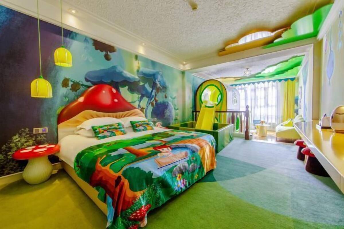 A colorful bedroom with a bed, a nightstand, and a window with curtains.